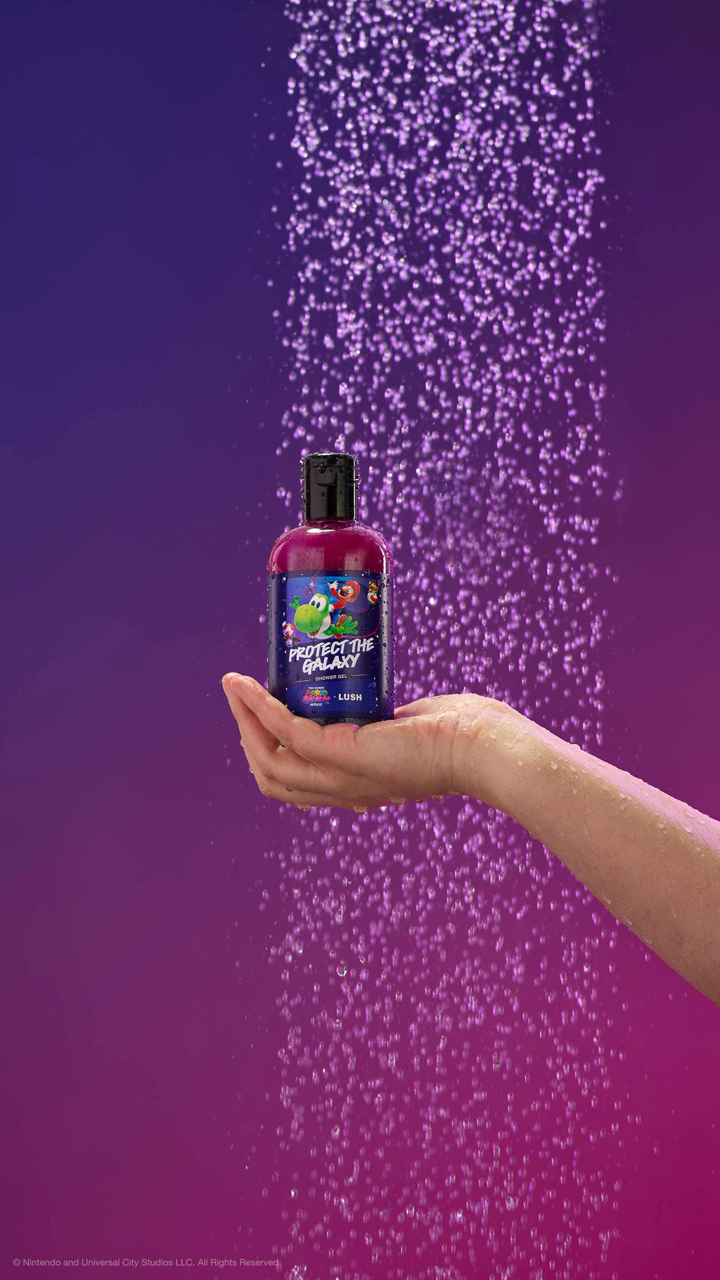 A hand holds a shimmering purple shower gel bottle under a spray of purple-tinted water. The label features Mario riding Yoshi. Against a purple gradient background. All glitter used is plastic-free.