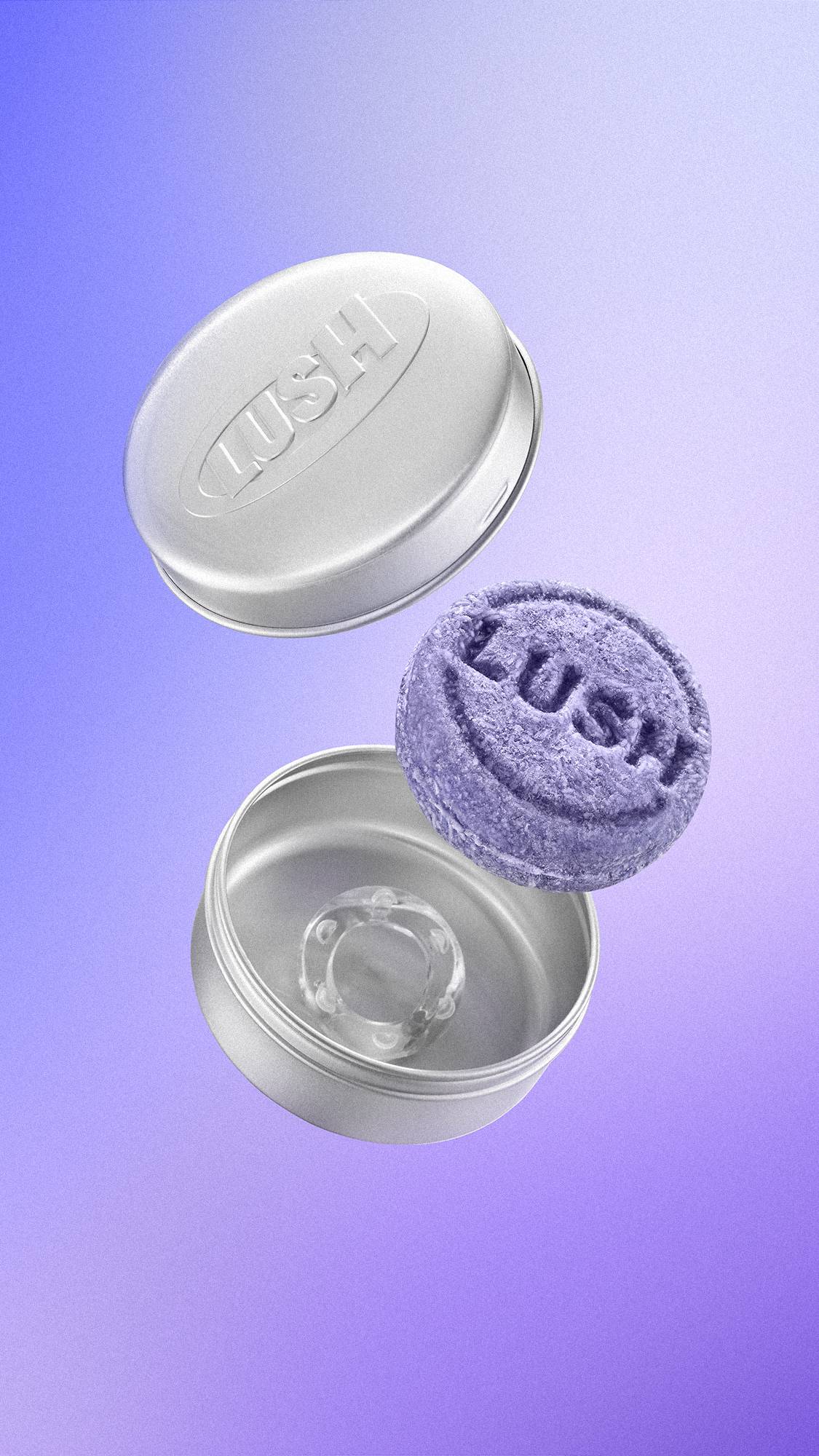 A textured purple Lush shampoo bar floats alongside an open, round silver metal tin with 'LUSH' embossed on the lid. A small clear ring rests inside the base, set against a purple gradient background.